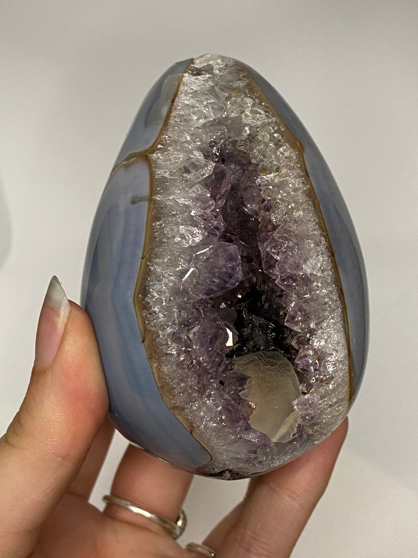 Blue agate and amethyst egg with calcite and tourmaline